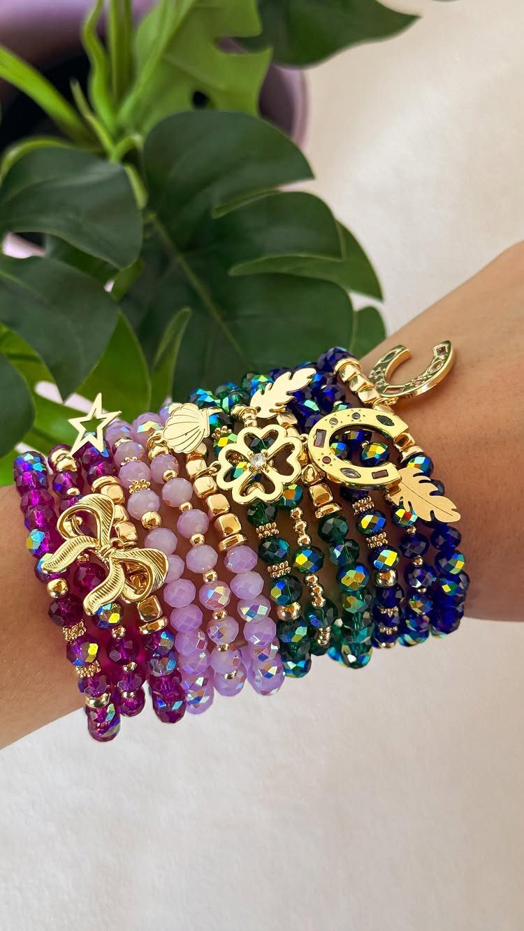 11 Beaded Jewelry DIY Bracelets Ideas for Every Style 2 Stacked beaded bracelets in purple, pink, and blue with gold charms on wrist