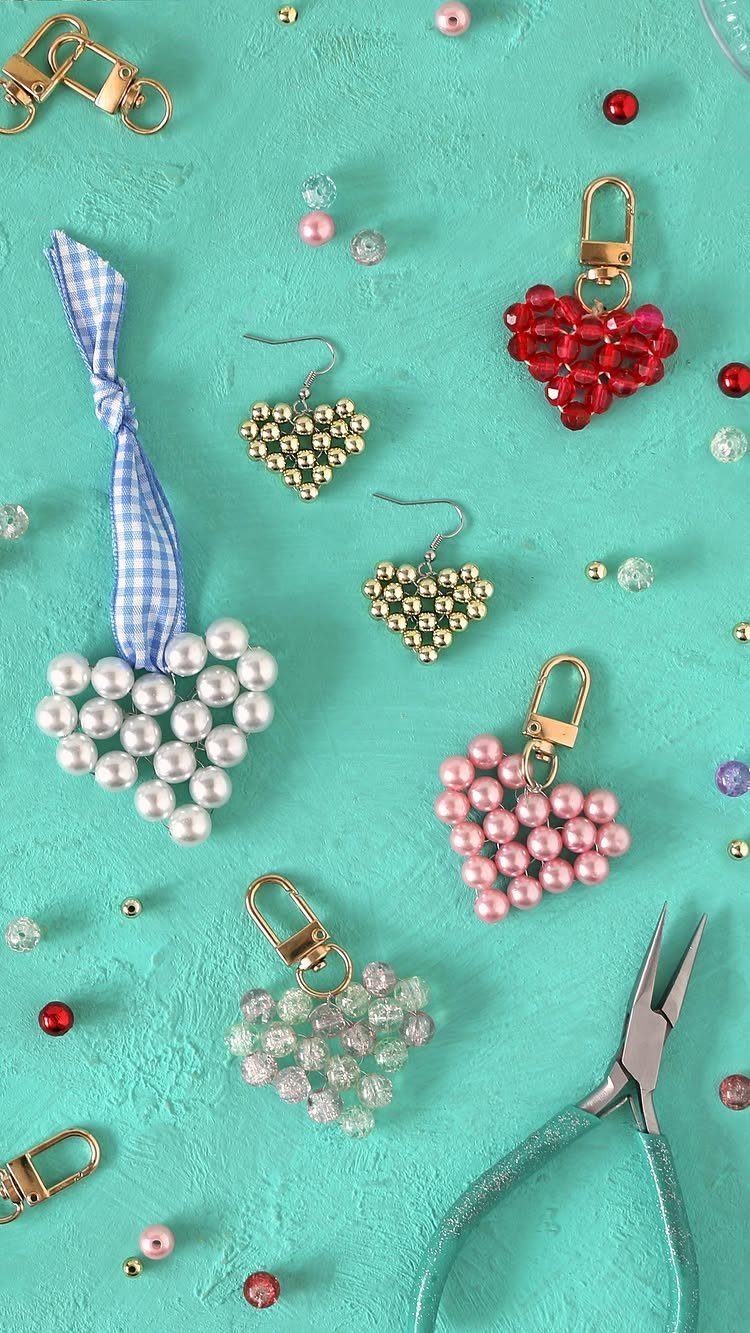 Heart-shaped beaded charms and earrings in various colors on a turquoise background.