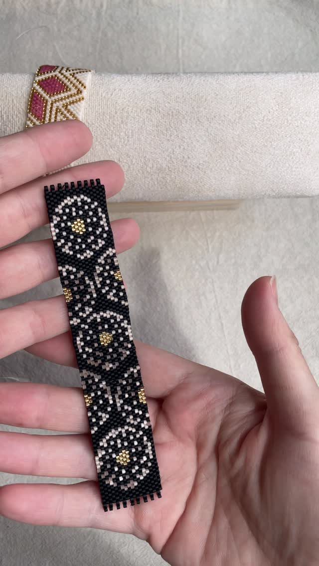 Beaded strip with black, white, and gold geometric circular patterns held in hand.