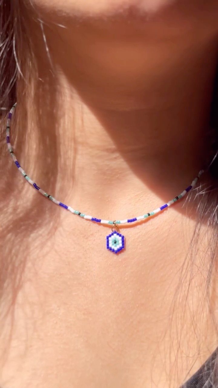 16 Beaded Jewelry Ideas to DIY (Bracelets, Necklaces & Earrings) 14 Beaded necklace with a blue hexagonal pendant worn around a person's neck.