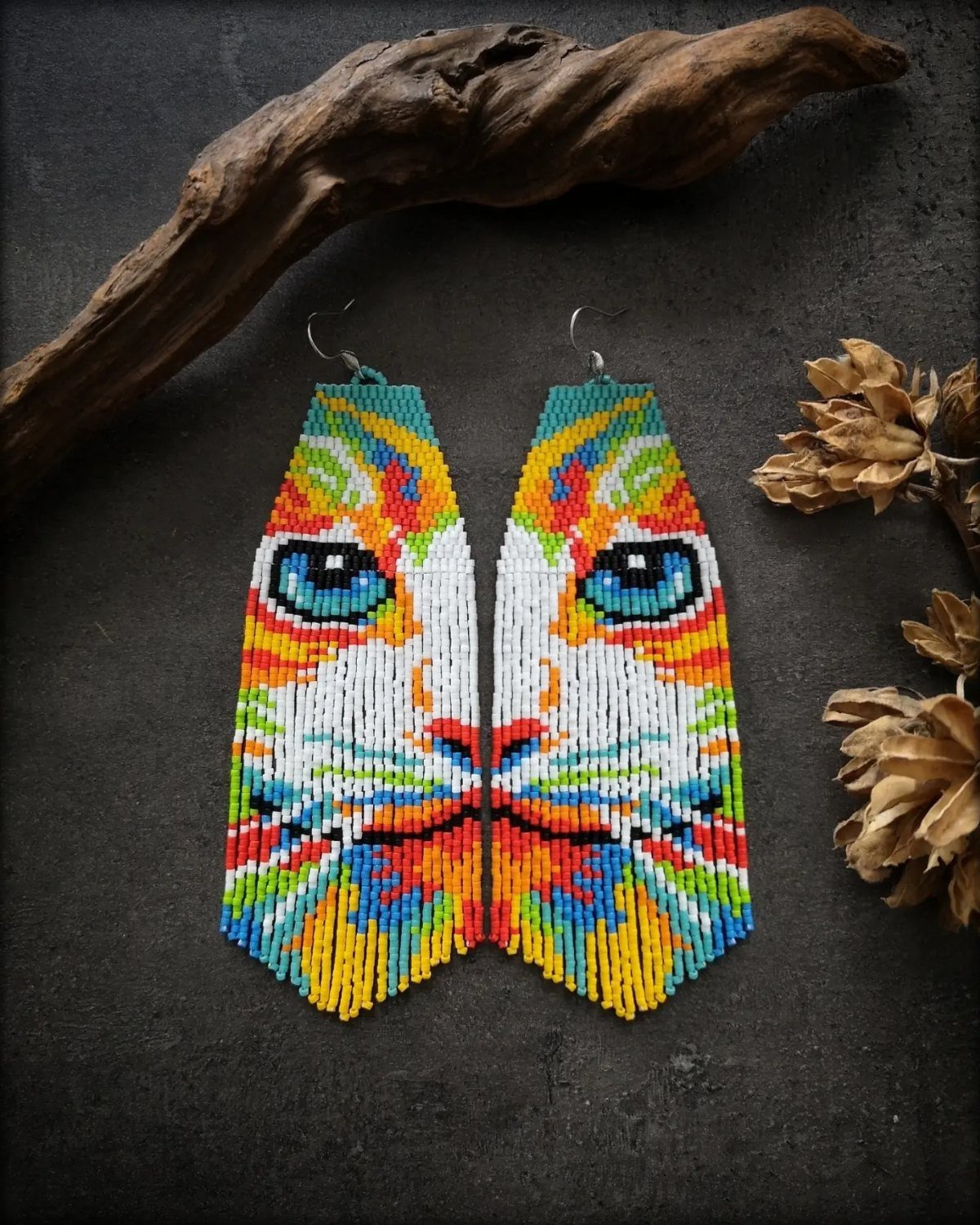 16 Beaded Jewelry Ideas to DIY (Bracelets, Necklaces & Earrings) 3 Beaded fringe earrings depicting a colorful cat face with bright blue eyes.