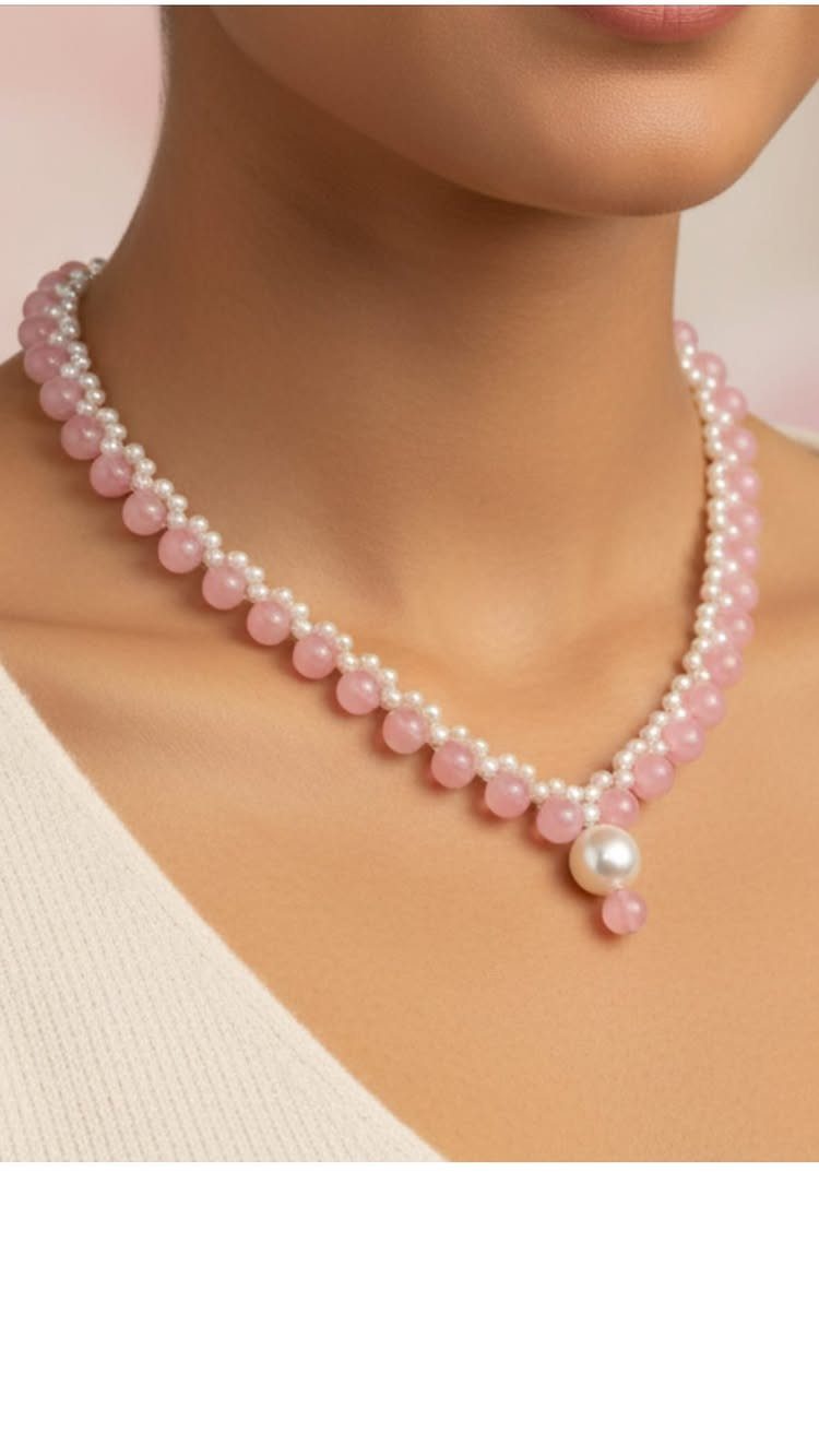 Beaded necklace with white pearls and pink beads worn on a person's neck