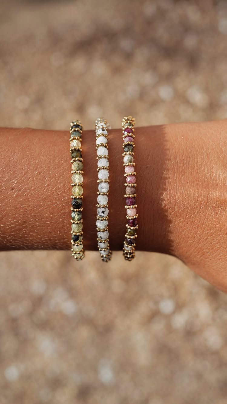 Beaded Jewelry Trends 2026: 8 Styles From Chunky Necklaces to Charm Accents 3 Three thin beaded bracelets in yellow, white, and pink on a wrist.