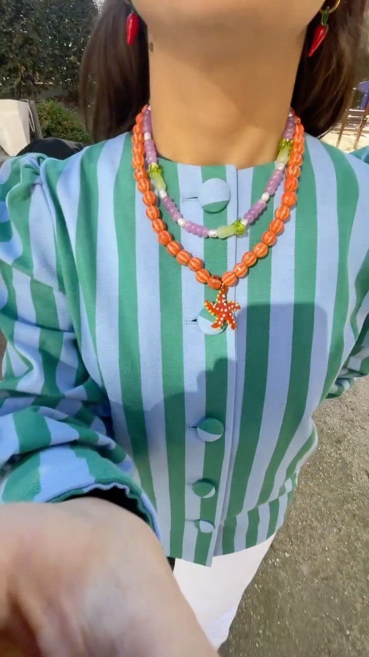 Beaded Jewelry Trends 2026: 8 Styles From Chunky Necklaces to Charm Accents 1 Chunky orange beaded necklace with starfish pendant and multicolored beads on striped shirt