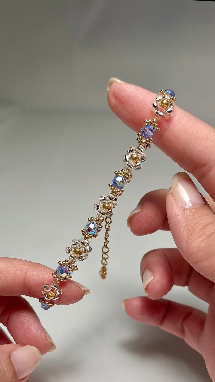 5 Beaded Jewelry with Wire Ideas: Bracelets, Links and Necklaces 4 Beaded gold wire bracelet with iridescent blue beads held by two hands.