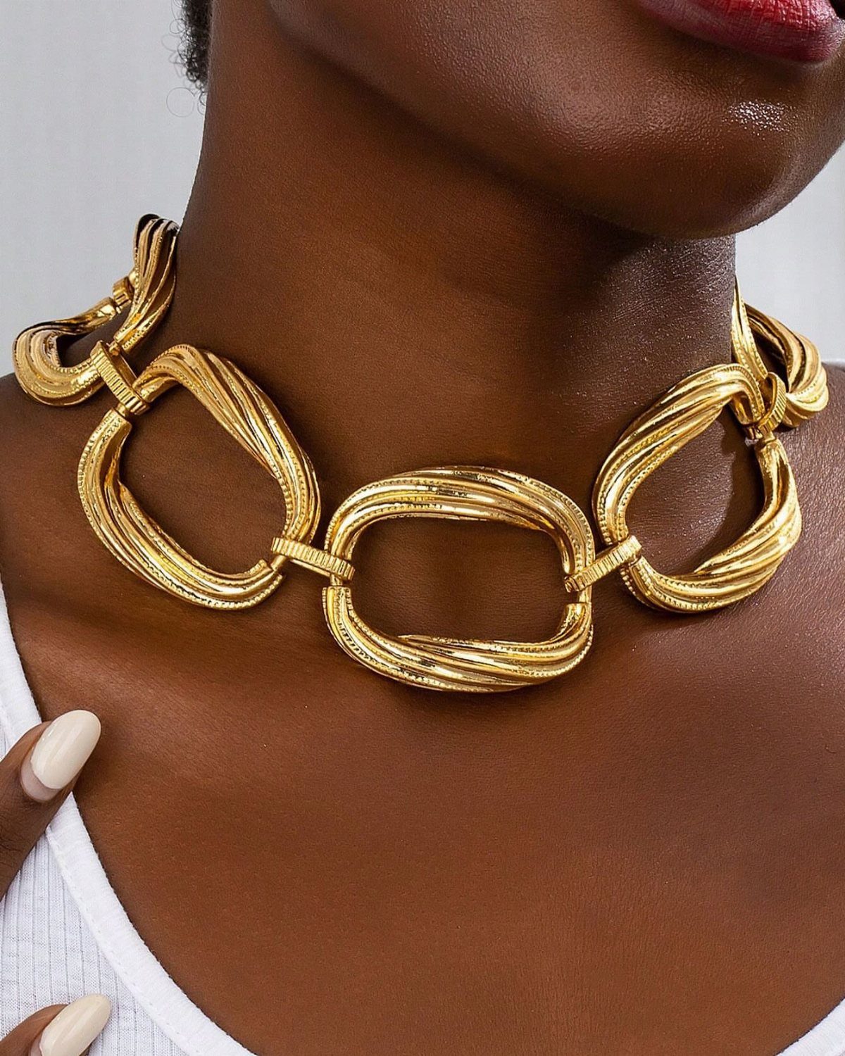 Bold Gold Jewelry: 9 Ways to Wear the Trend in 2026 6 Chunky gold chain necklace with large textured oval links on a person
