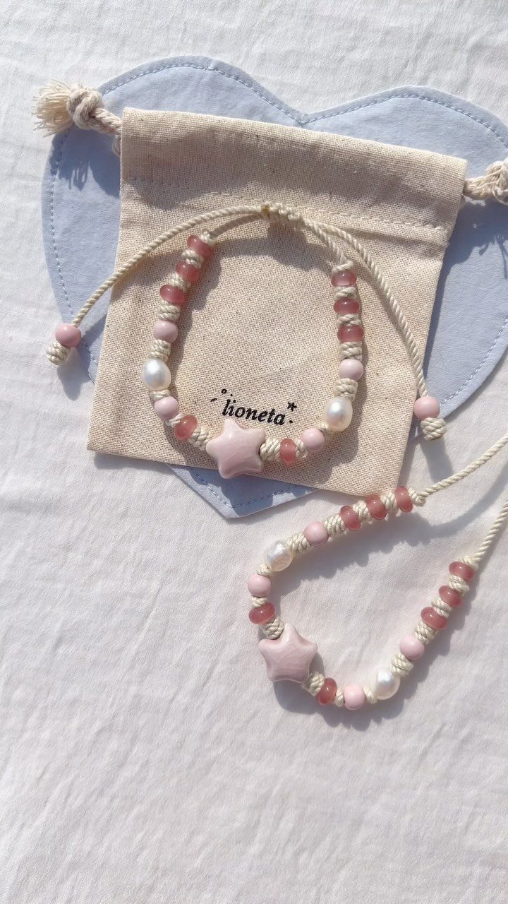 5 DIY Bracelets: Easy Beads Projects With Stretchy, Multi-Strand & More 3 Two pink and white beaded bracelets with star charms on a fabric pouch