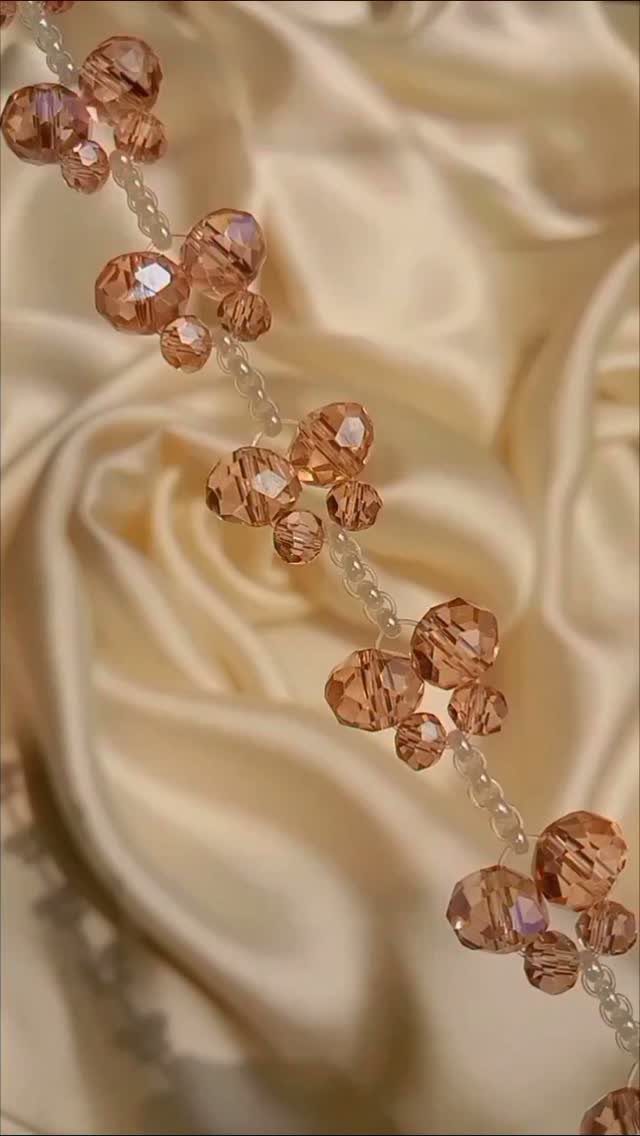 5 DIY Bracelets: Easy Beads Projects With Stretchy, Multi-Strand & More 4 Beaded bracelet with peach faceted crystals resting on champagne satin fabric