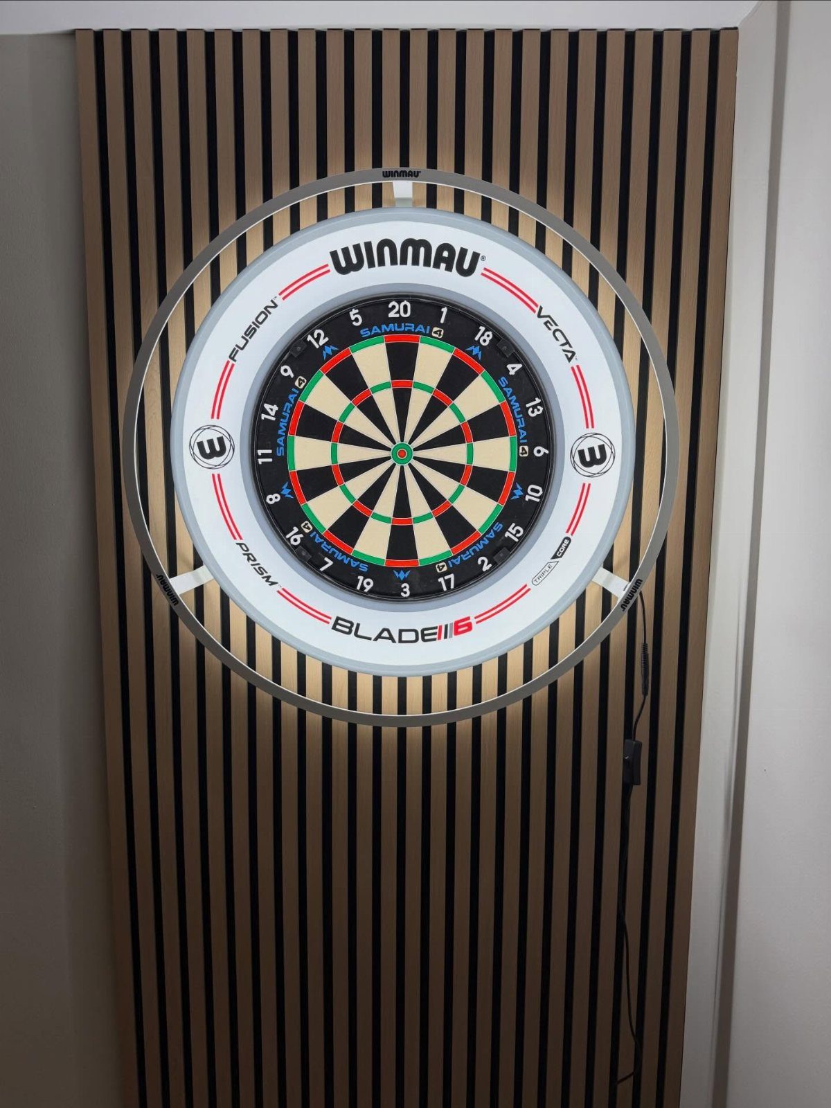 DIY Dart Board Backboard: 7 Clever Projects for Any Style 5 Winmau dartboard mounted on a modern wooden slat backboard against a white wall