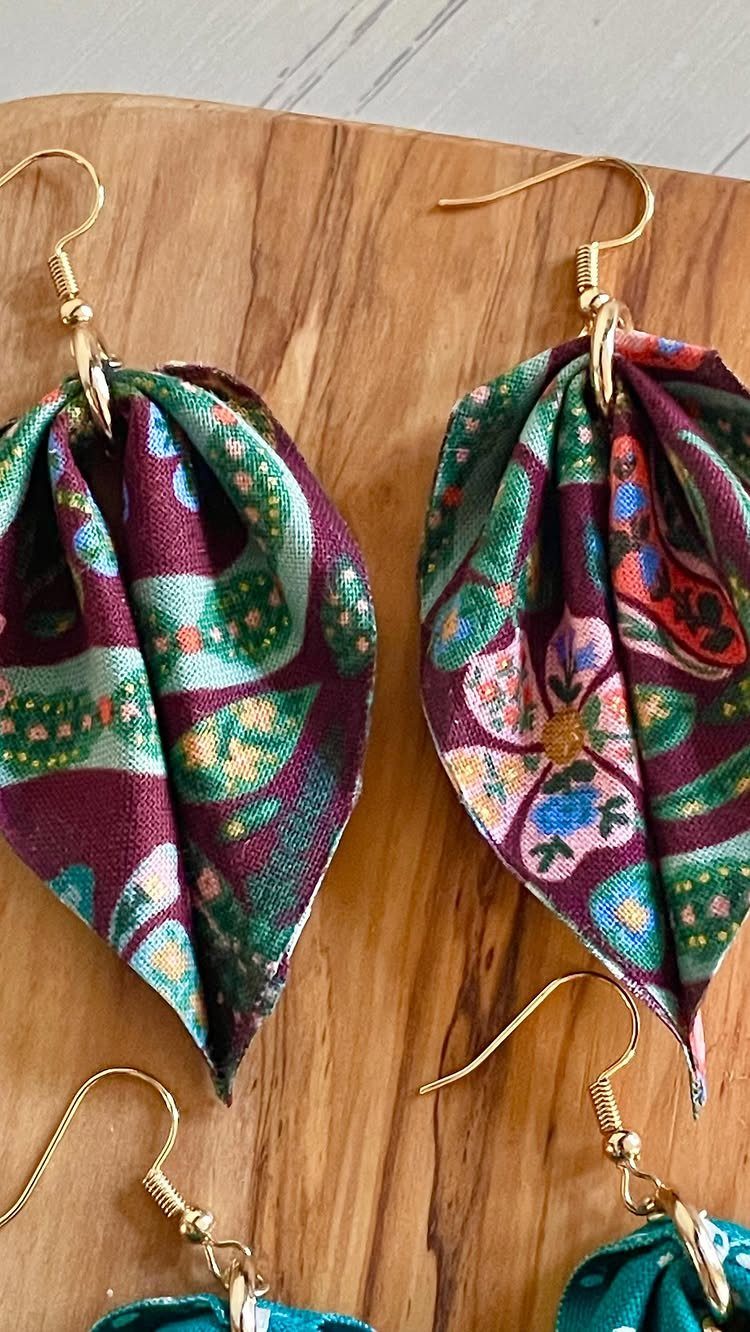 5 Fabric Jewellery Design Ideas for Necklaces, Bracelets and More 4 Fabric earrings with pleated purple and green patterns on a wooden background