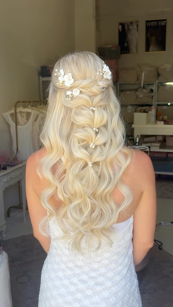 Long wavy blonde hair styled with braids and white floral hair accessories.