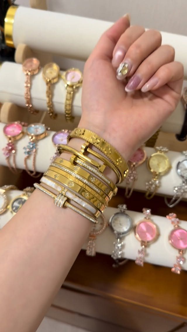 Stack of gold bangles with crystals on a wrist in a jewelry store