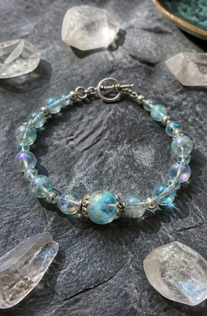 20 Handmade Jewelry Tutorials for Bracelets We Love 10 Aqua Aura Bracelet displayed on a slate surface.
