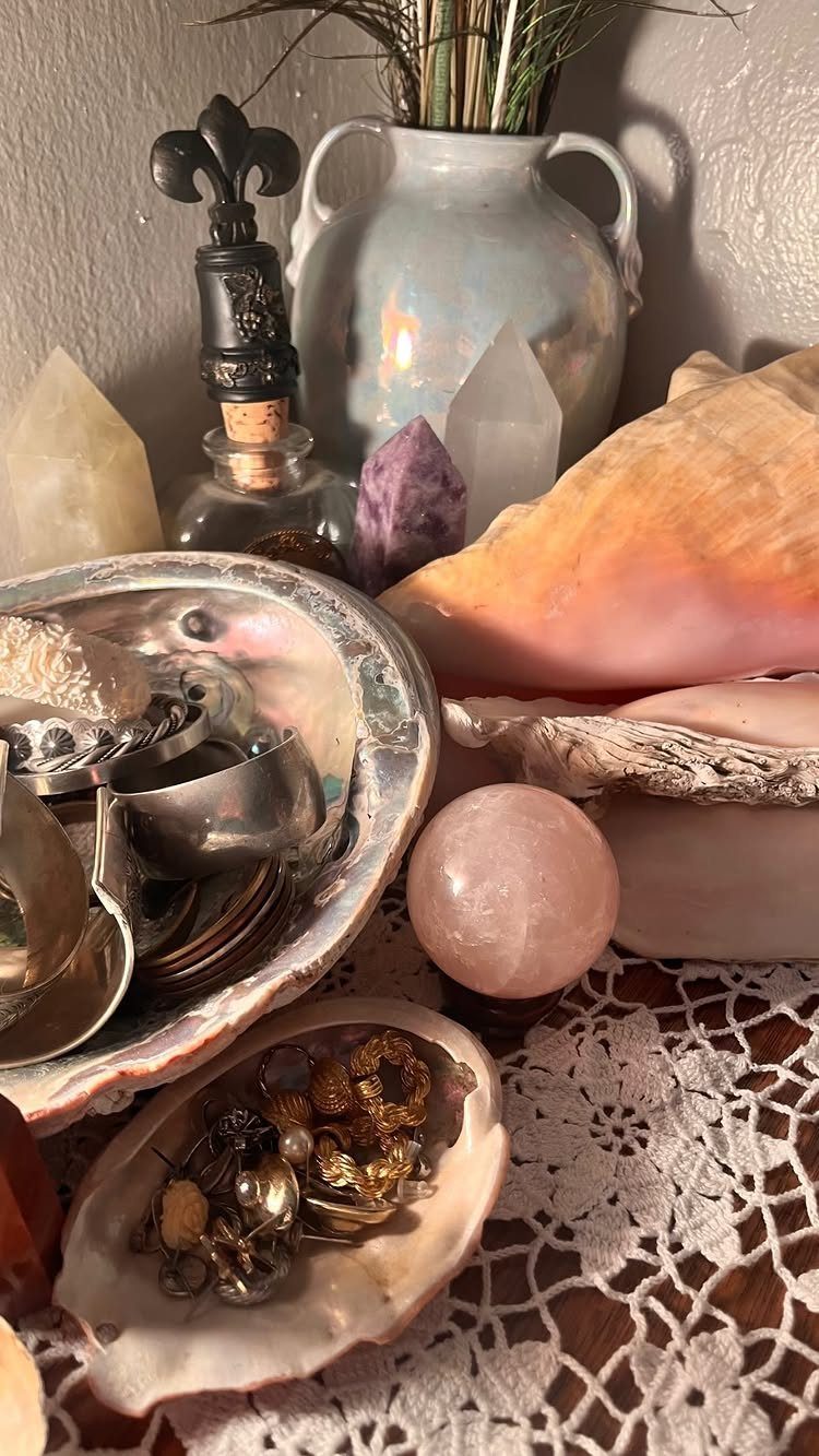 12 Ideas for Organizing Jewelry: Wall, Drawer & Travel Storage 12 Jewelry stored in iridescent seashells alongside crystals and a pink stone sphere.