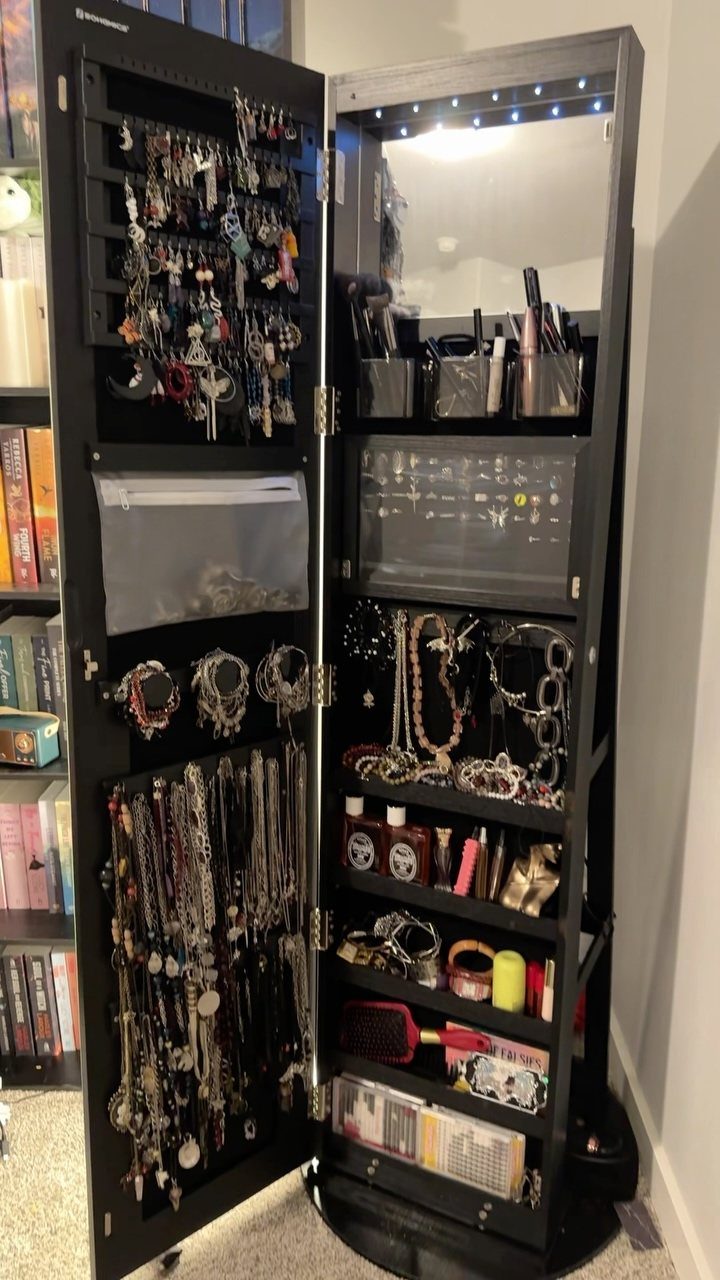 12 Ideas for Organizing Jewelry: Wall, Drawer & Travel Storage 6 Black jewelry cabinet open to reveal organized necklaces, earrings, and makeup accessories.