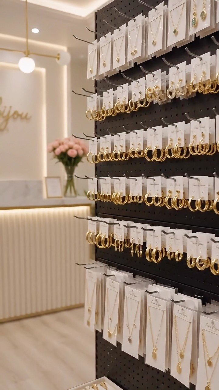12 Ideas for Organizing Jewelry: Wall, Drawer & Travel Storage 8 Black pegboard displaying gold hoop earrings and necklaces on white cards in a store