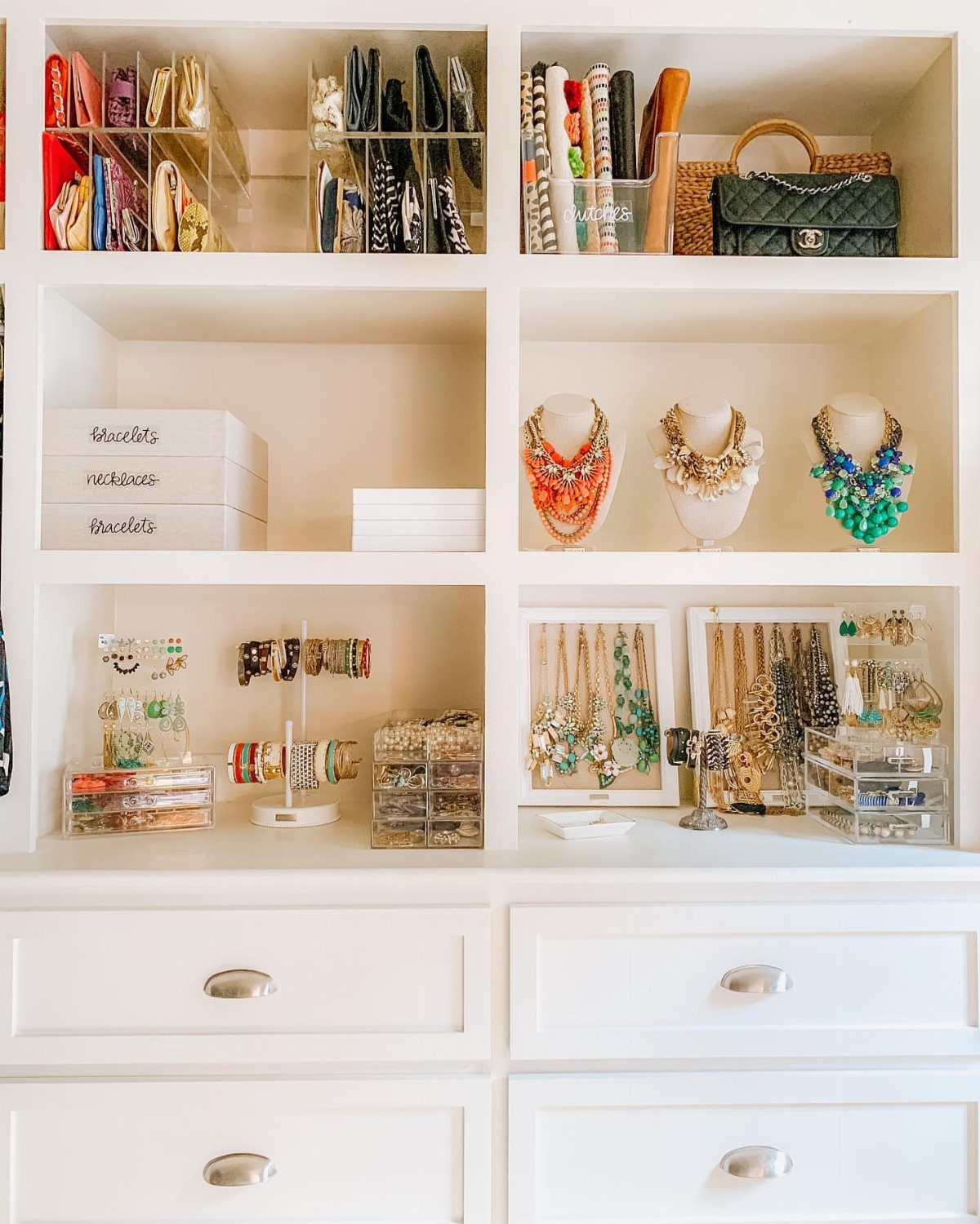 12 Ideas for Organizing Jewelry: Wall, Drawer & Travel Storage 2 White shelving unit with various jewelry organizers holding colorful necklaces and bracelets.