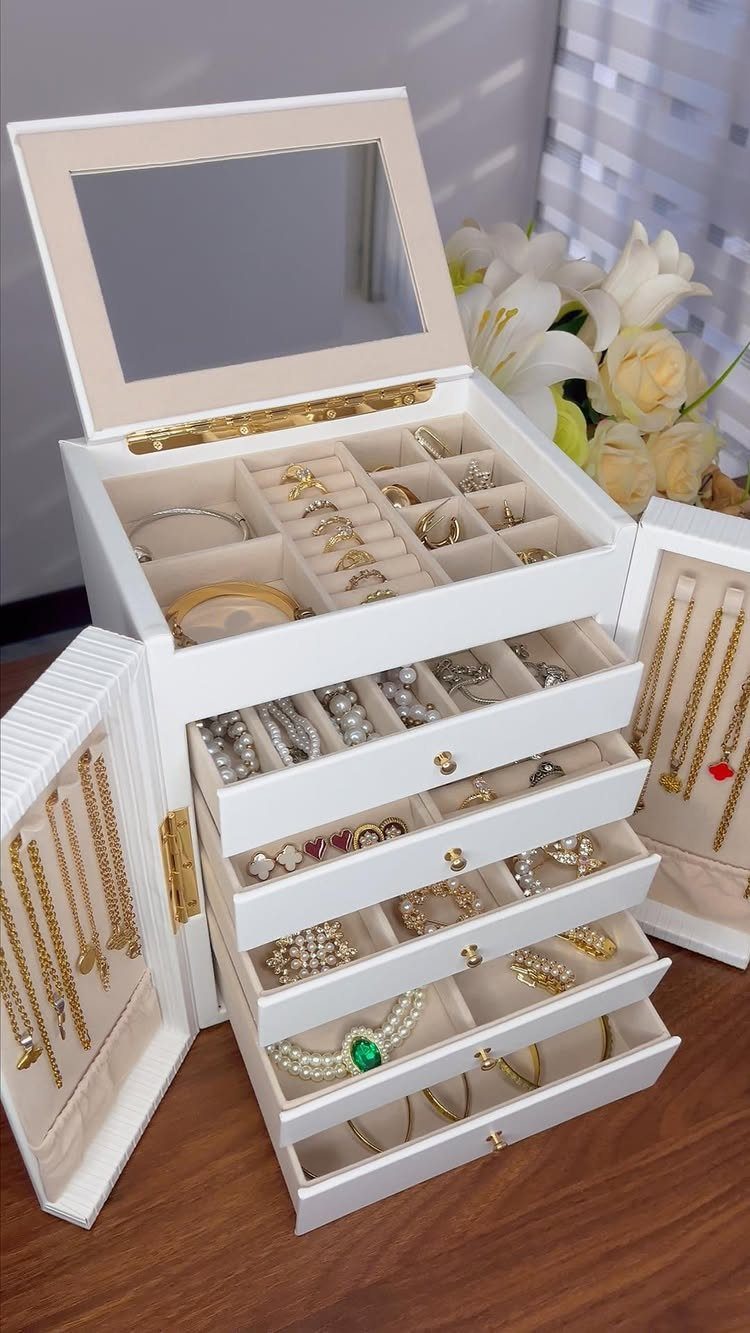 12 Ideas for Organizing Jewelry: Wall, Drawer & Travel Storage 10 White multi-tiered jewelry box filled with gold rings and necklaces on wooden table