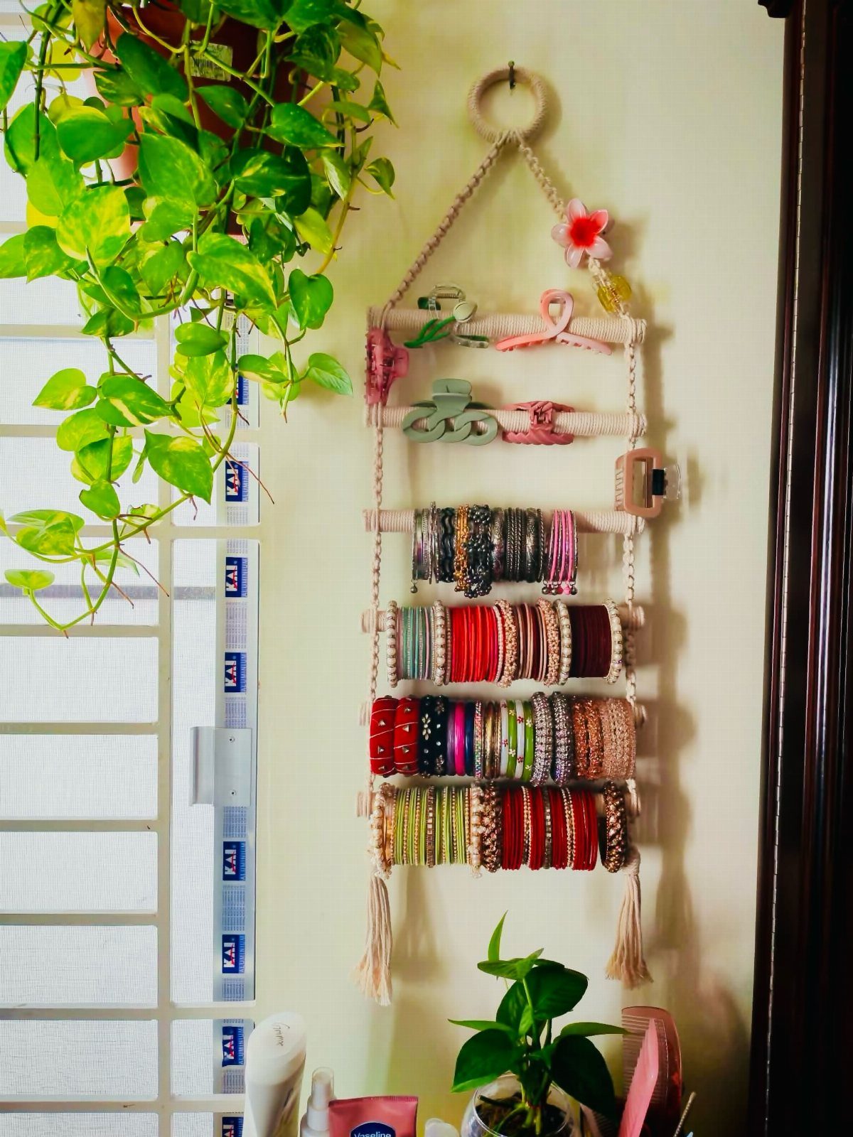 12 Ideas for Organizing Jewelry: Wall, Drawer & Travel Storage 1 Wall-mounted jewelry organizer holding colorful bangles and bracelets next to green plants