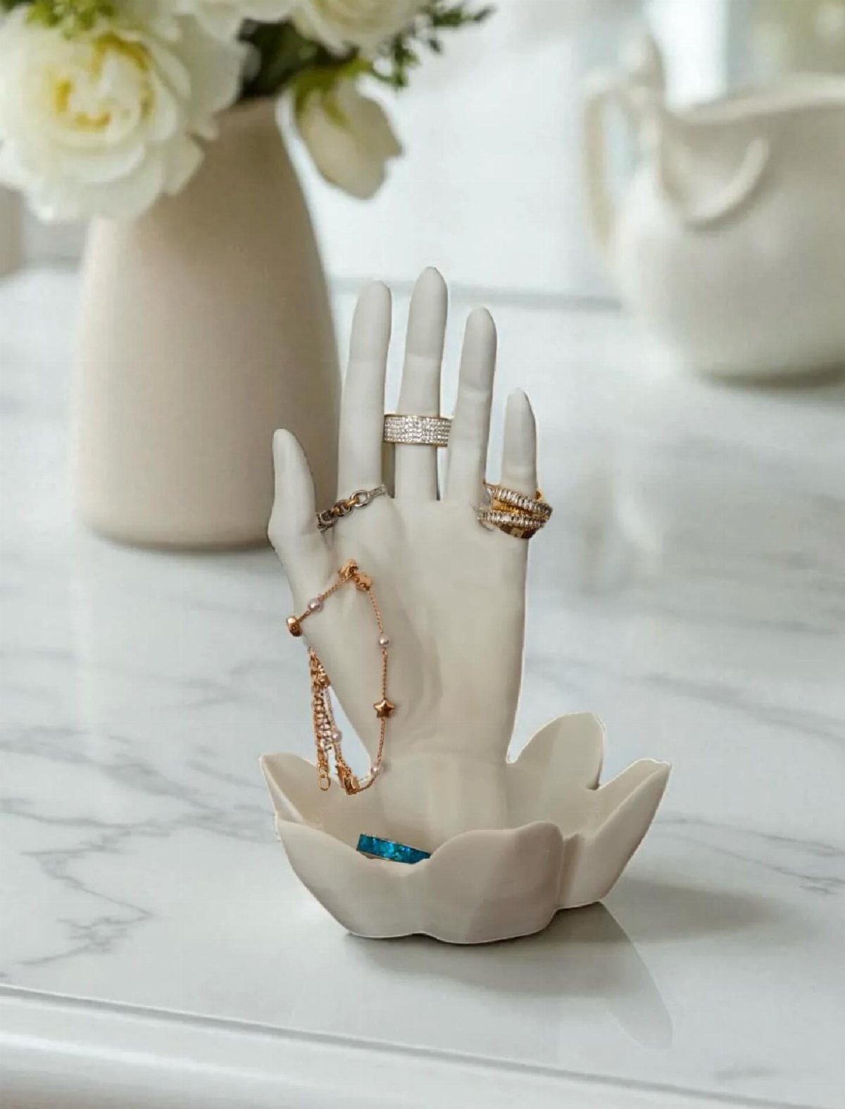 10 Jewellery Holder Ideas for Every Dressing Table 7 White ceramic hand jewelry holder with rings and bracelet on marble surface