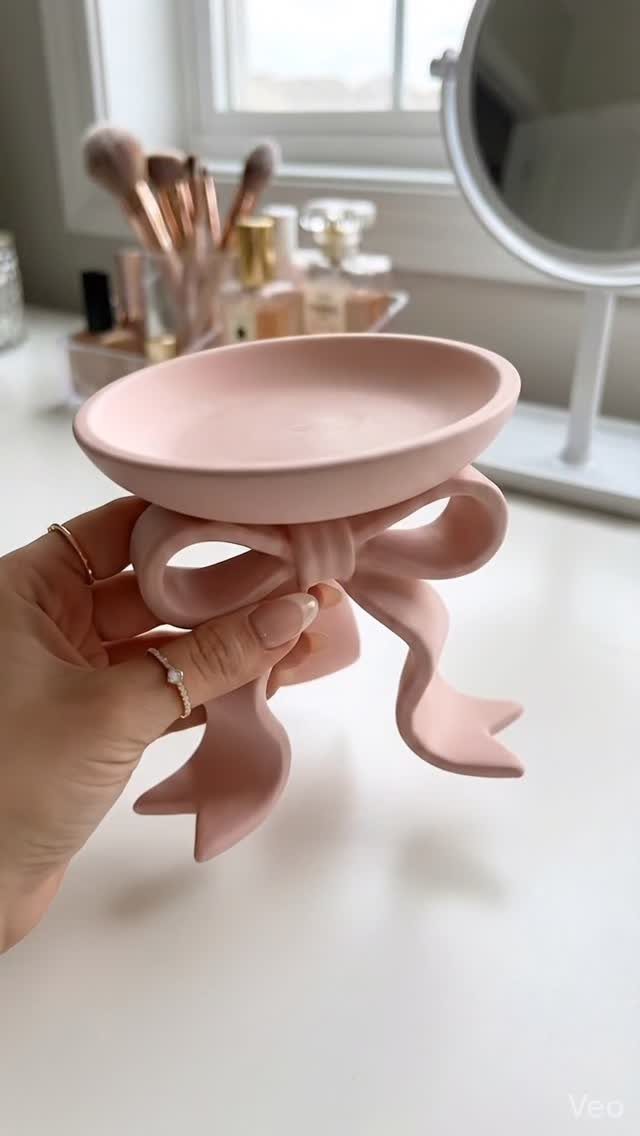 10 Jewellery Holder Ideas for Every Dressing Table 1 Pale pink ceramic jewelry dish shaped like a bow held by a hand