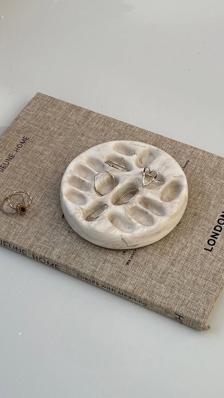 10 Jewellery Holder Ideas for Every Dressing Table 5 Marbled clay ring dish holding silver rings on a linen book cover