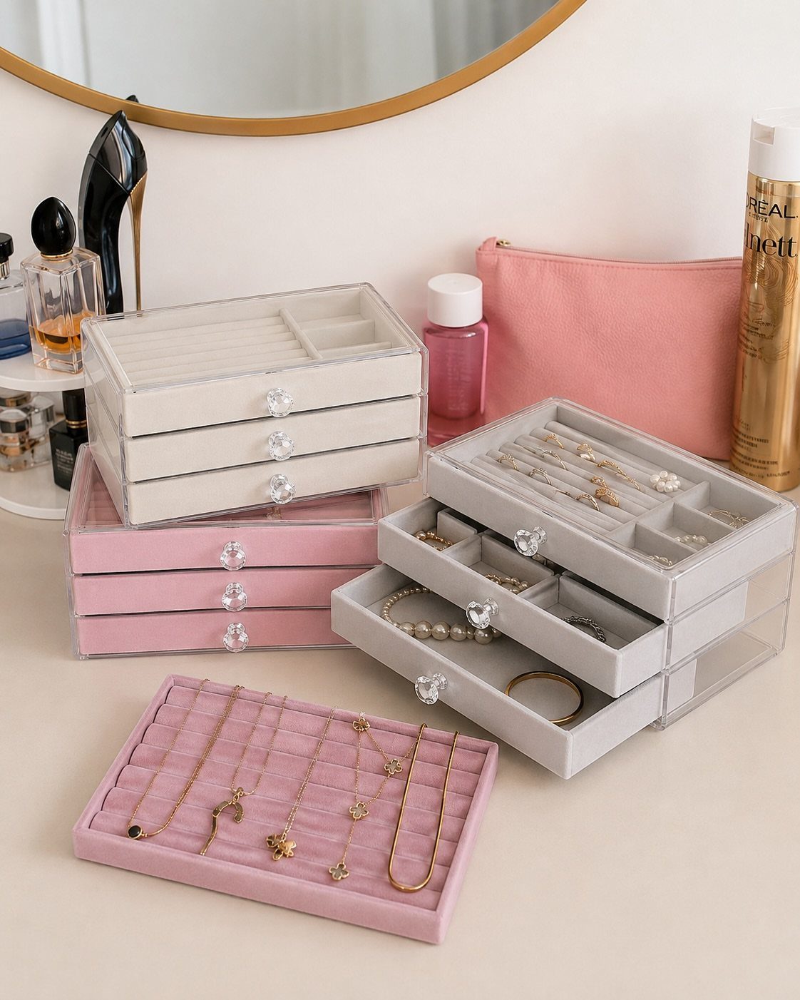 10 Jewellery Holder Ideas for Every Dressing Table 2 Velvet-lined acrylic jewelry boxes in pink, white, and grey holding various necklaces and rings.