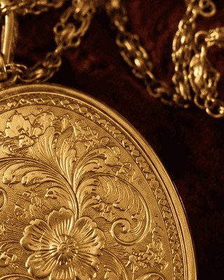 19 Jewelry Aesthetic Gold Ideas for Easy Style 17 Oval gold locket with detailed floral engravings on a dark velvet background
