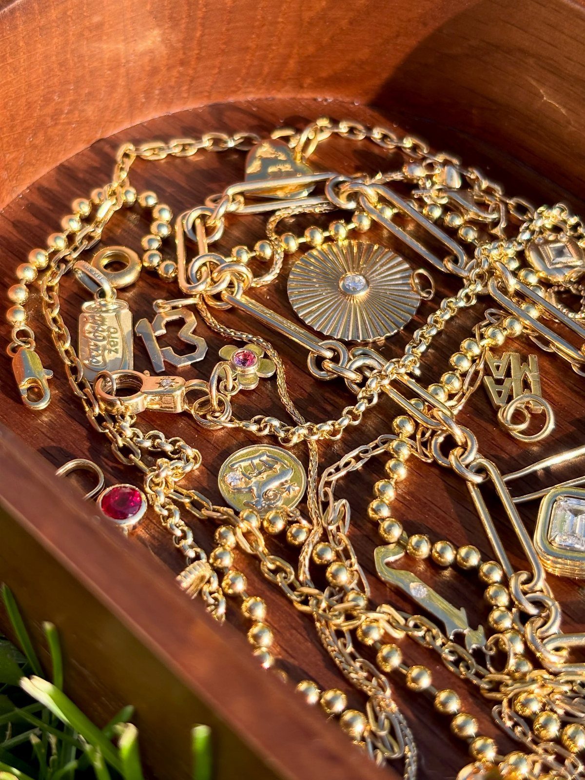 19 Jewelry Aesthetic Gold Ideas for Easy Style 18 Gold jewelry collection with various chains and medallions inside a wooden bowl.