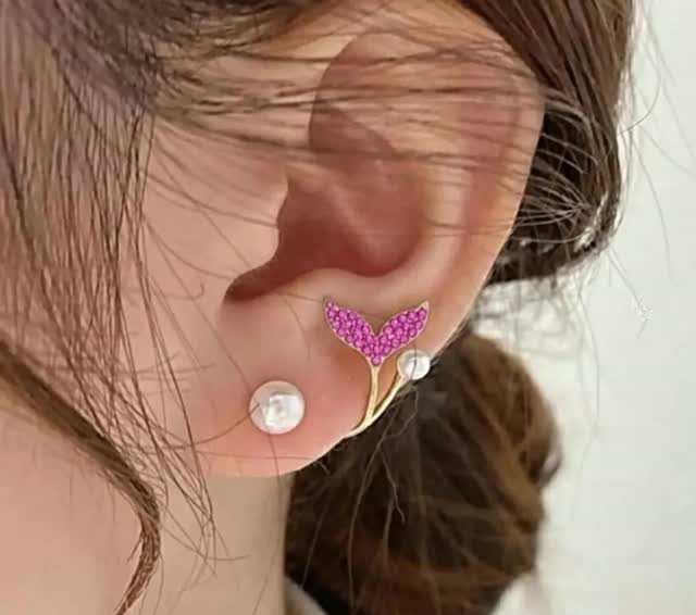 19 Jewelry Aesthetic Gold Ideas for Easy Style 8 Ear with multiple gold and pearl piercings including a pink mermaid tail earring.