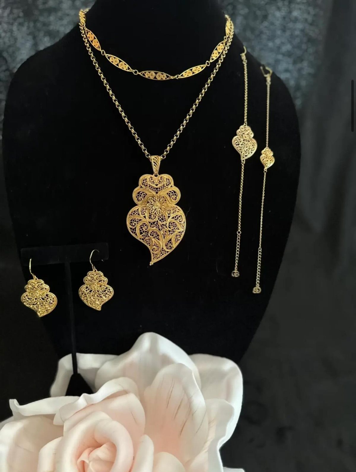 19 Jewelry Aesthetic Gold Ideas for Easy Style 4 Gold filigree jewelry set with heart pendant and earrings on black velvet bust.