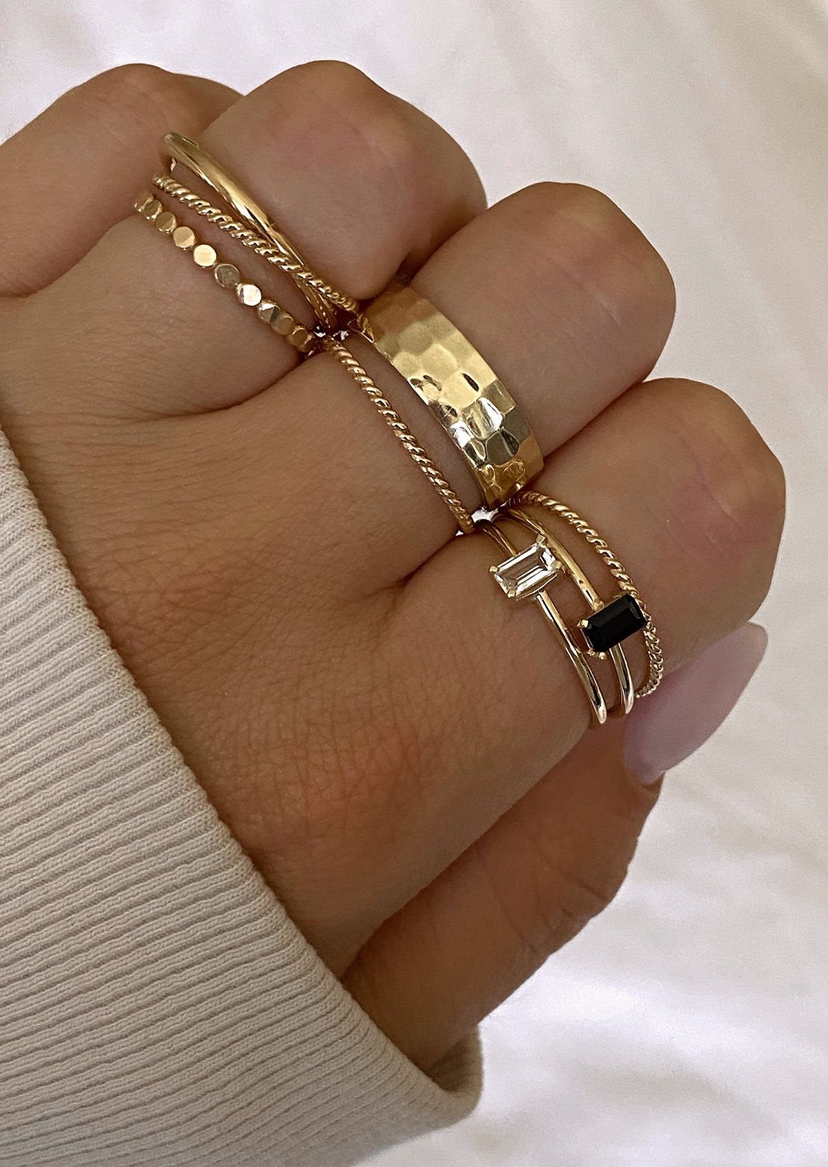 19 Jewelry Aesthetic Gold Ideas for Easy Style 6 Multiple gold rings of various textures and styles stacked on a hand.