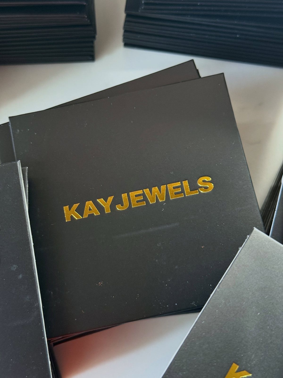 9 Jewelry Brand Logos From Tiffany Blue to Swarovski Swan 8 Black jewelry boxes featuring the gold metallic KAYJEWELS brand logo on the lids.