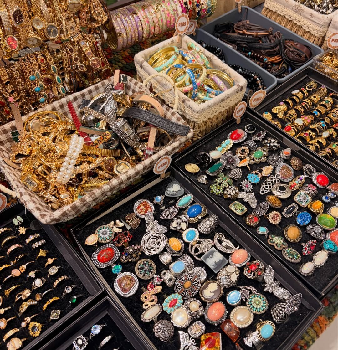 19 Jewelry Posting Ideas for Instagram That Build Sales 6 Assorted jewelry including rings and bracelets displayed in baskets and trays at a market.