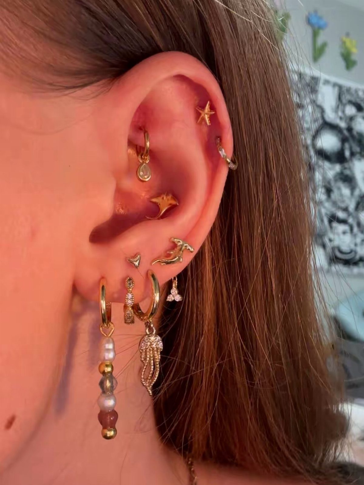 12 Jewelry Stack Inspo Earrings Ideas 6 Gold earring stack with a wing charm, dolphin, and beaded dangling earring.