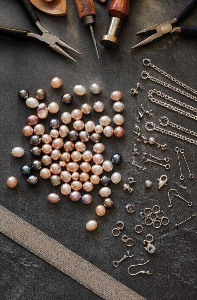 A collection of freshwater pearls and jewelry findings on a table.