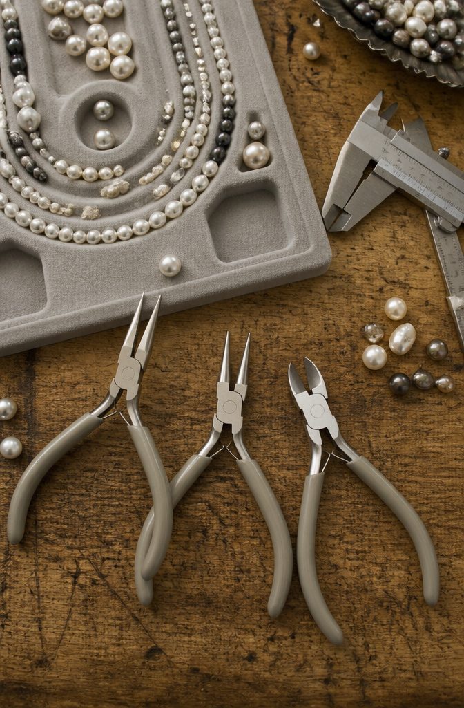 Chain-nose, round-nose, and flush cutters arranged on a work surface.