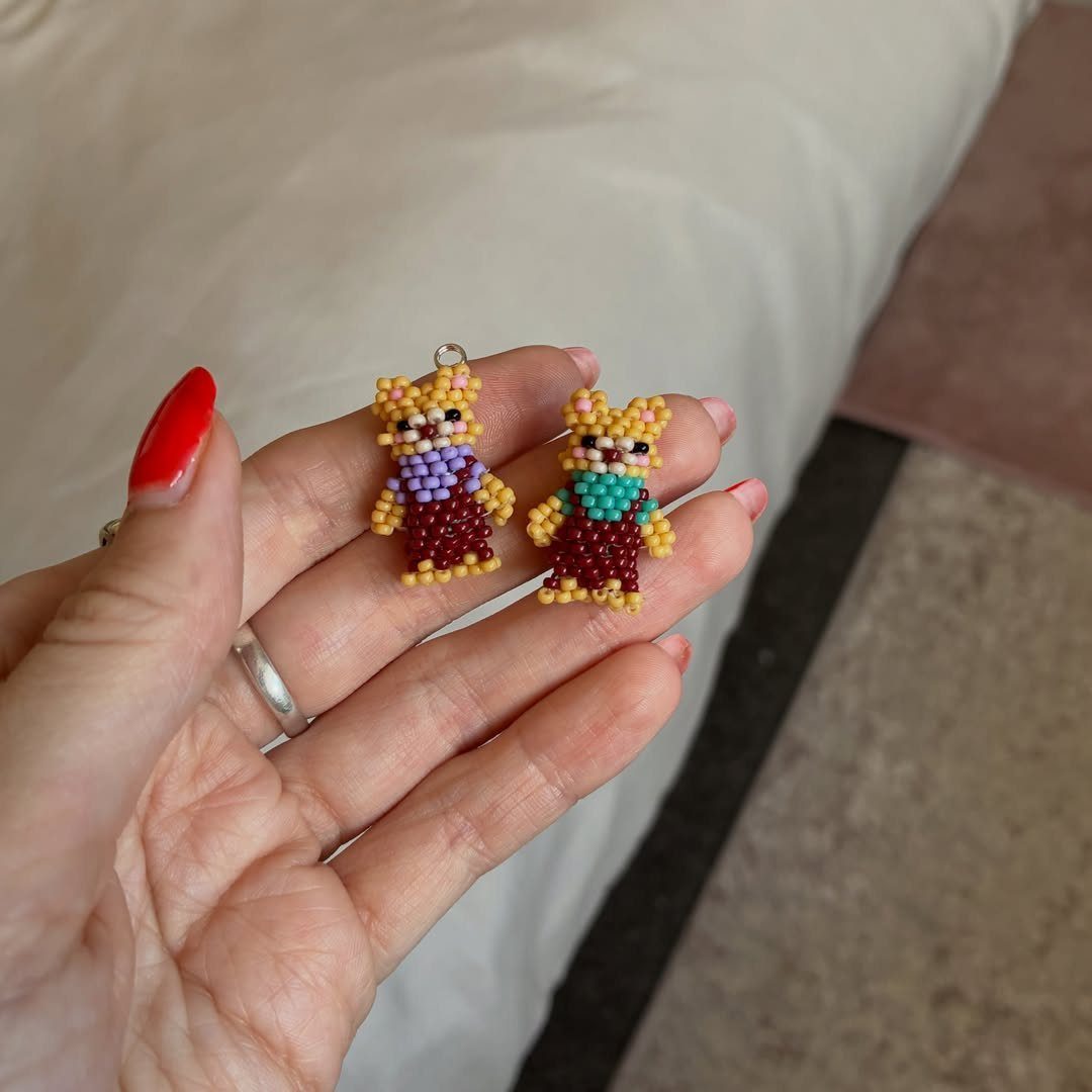 Seed Bead Crafts: 19 Patterns and Projects for 2026 9 Two small yellow seed bead bear earrings held in a person's hand.