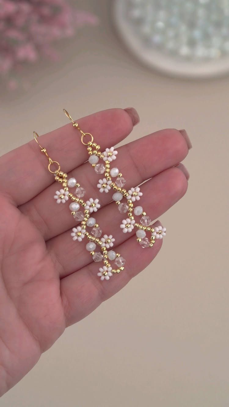 Seed Bead Crafts: 19 Patterns and Projects for 2026 16 Hand-crafted seed bead earrings with white floral patterns and pale pink accents.