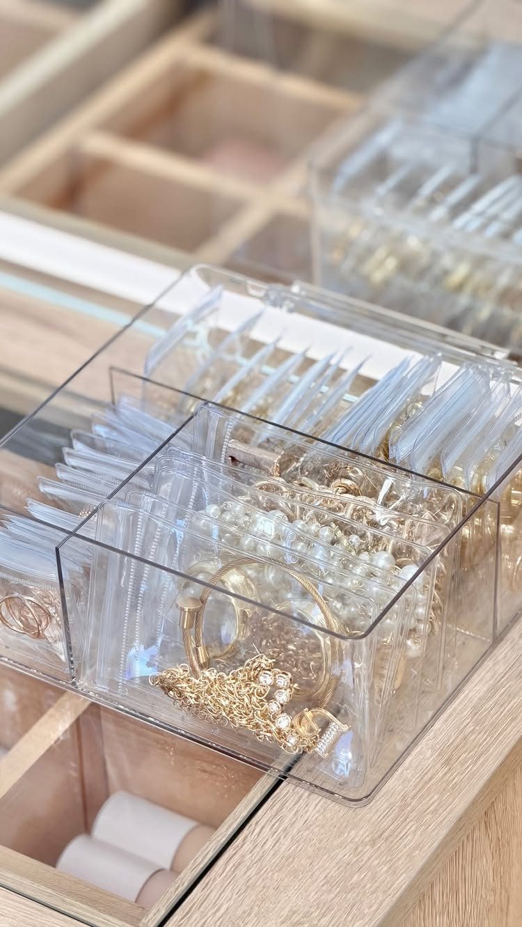 13 Stud Earring Storage Ideas for Every Jewelry Collection 5 Clear acrylic drawer inserts organizing gold and pearl jewelry in a wooden drawer.
