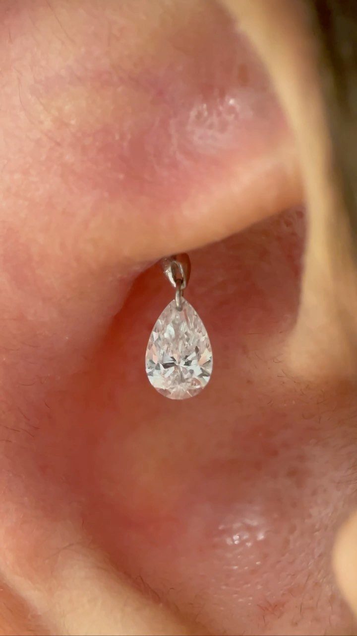 Top of the Ear Piercing Jewelry: 11 Ideas 6 Pear-shaped clear gemstone earring in a conch piercing on a human ear.