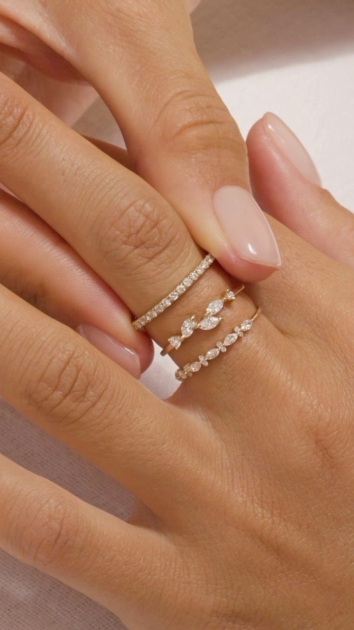 XOXO Jewelry Ideas: 10 Ways to Wear These Timeless Symbols 7 Three stacked gold rings with small diamonds on a woman's finger.